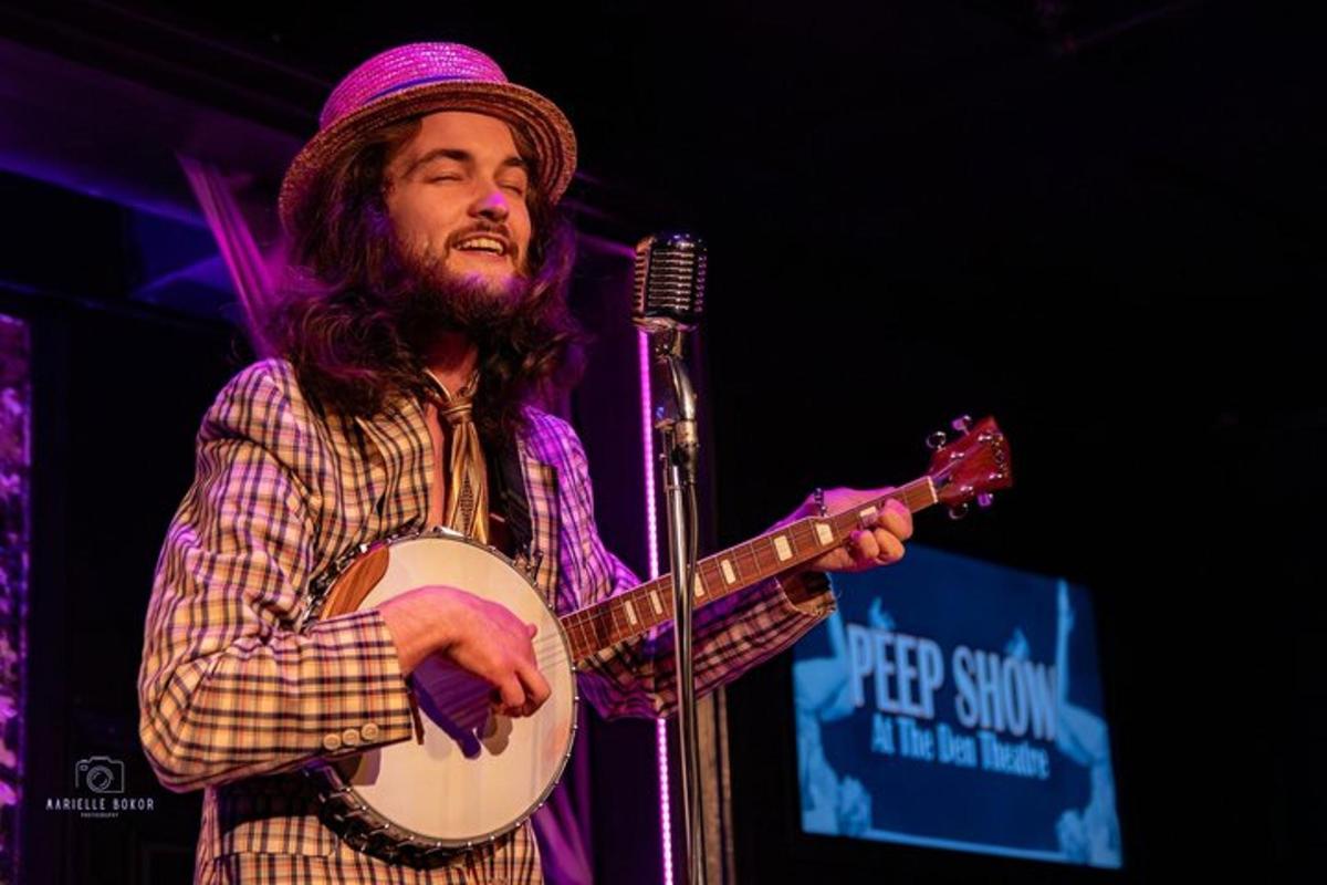 a man is playing a guitar on a stage