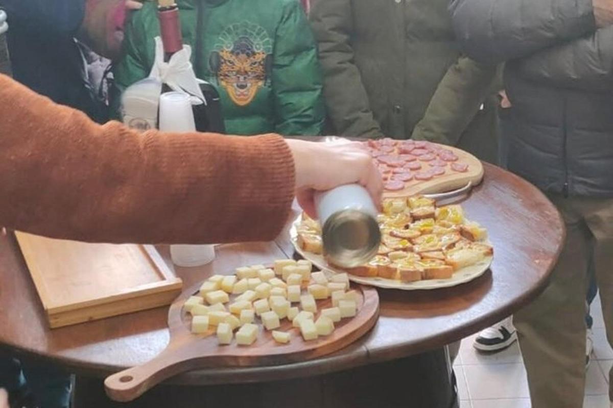 a person is pouring a drink from a pot next to pies