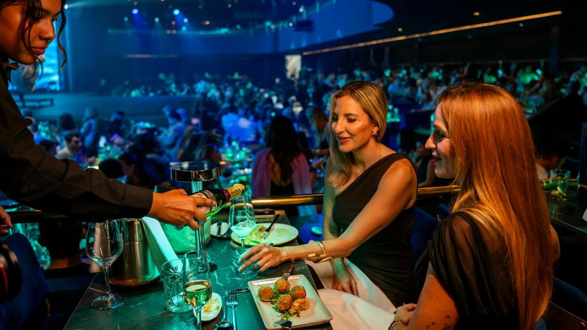 a group of people sitting at a bar eating food