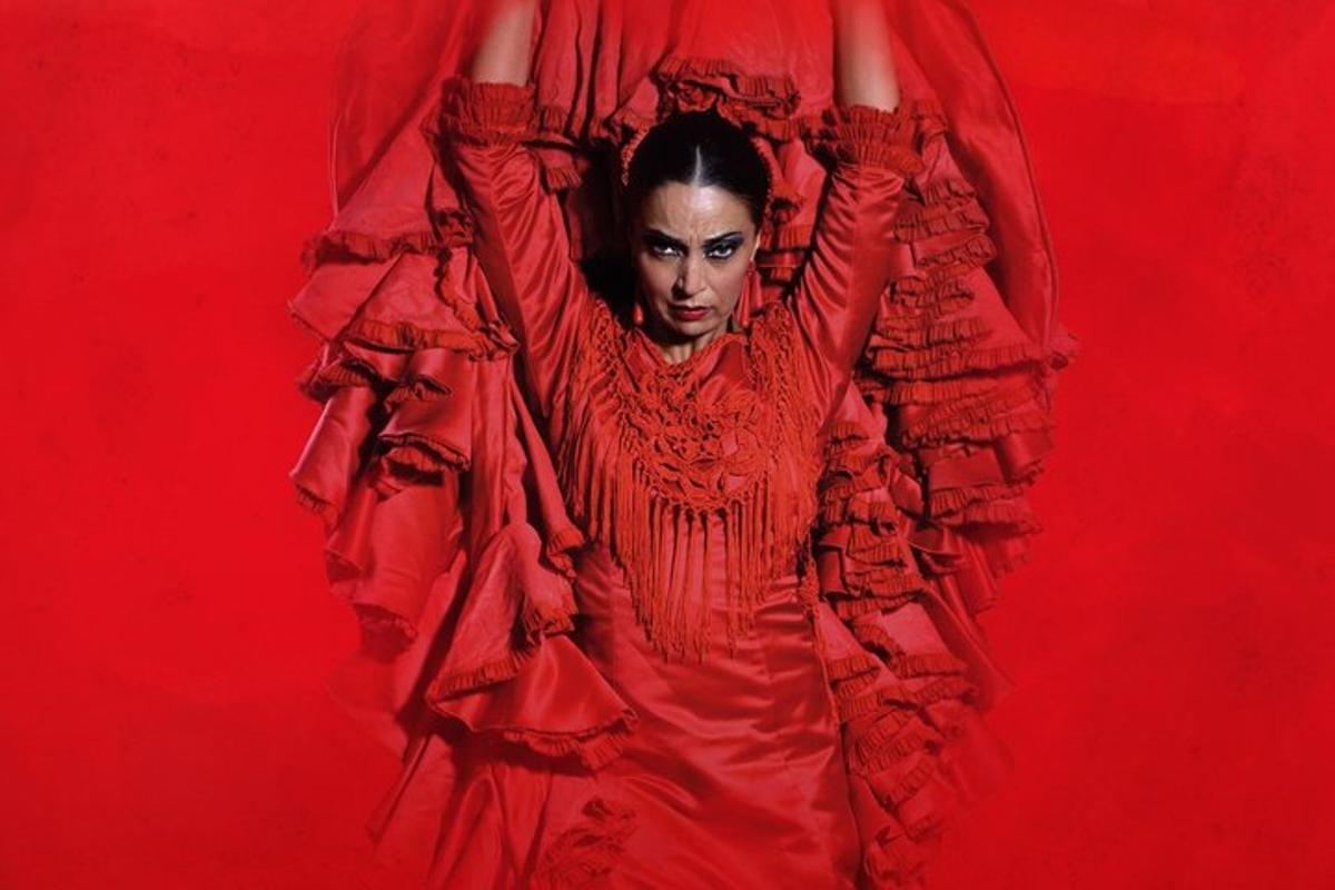 una mujer con un vestido rojo con los brazos levantados