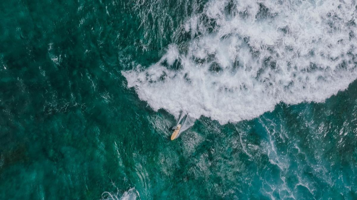 an overhead view of a surfboard in the ocean
