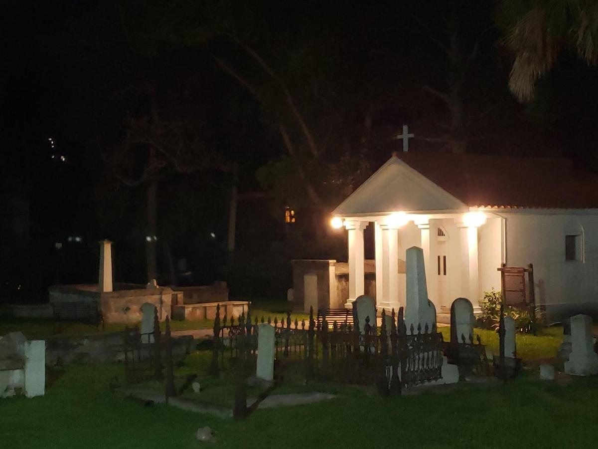a small white church at night with lights on it