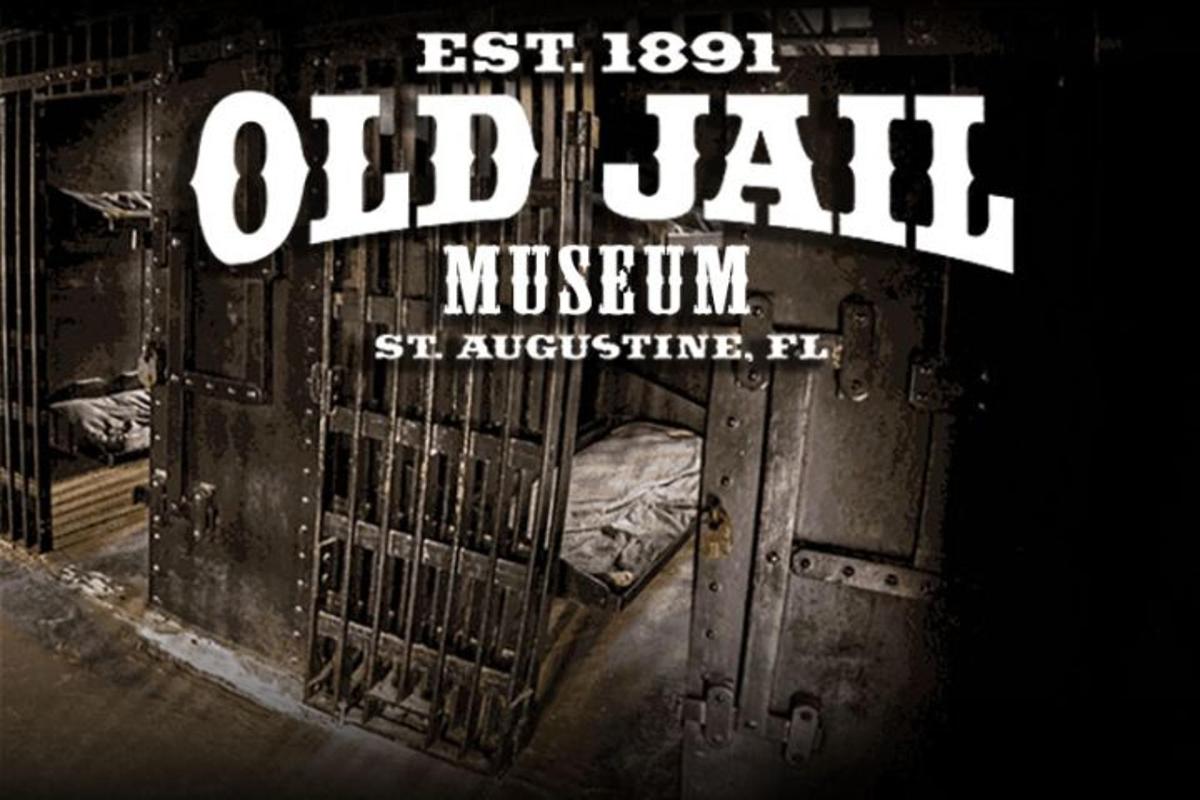 an old jail with an open door with a bed in it