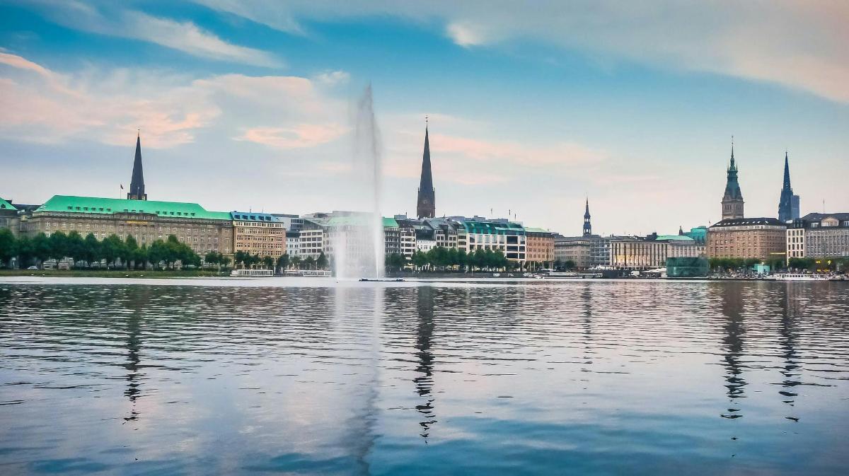 a city with a fountain in the middle of a body of water