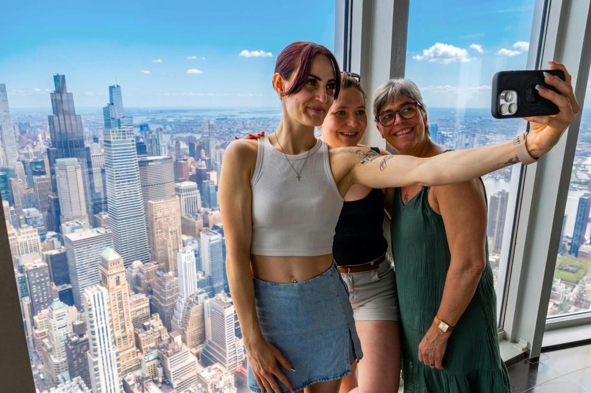 three women posing for a picture in a skyscraper