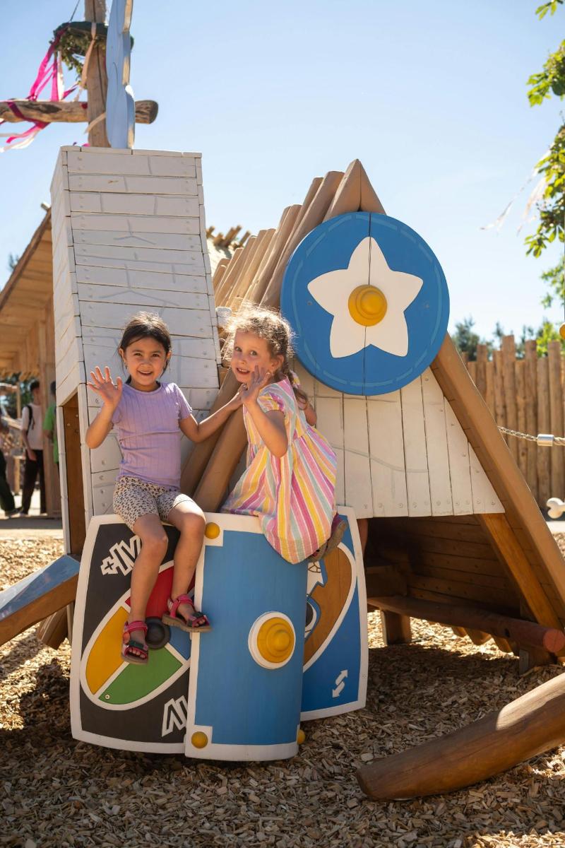 two little girls sitting on a play structure