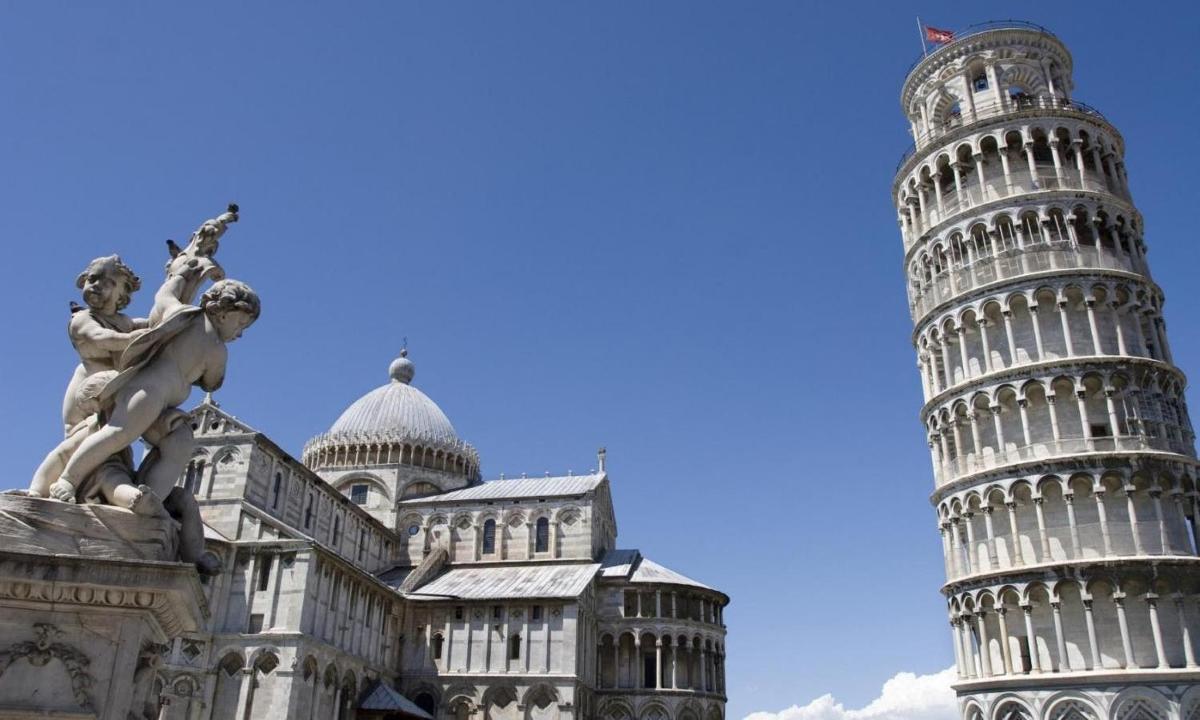 a statue in front of a building with the leaning tower