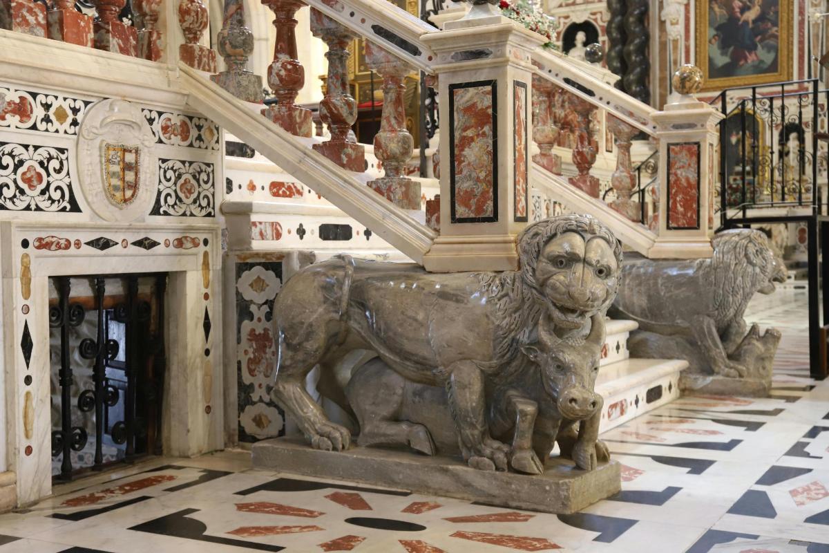 a statue of a lion in a room with a staircase
