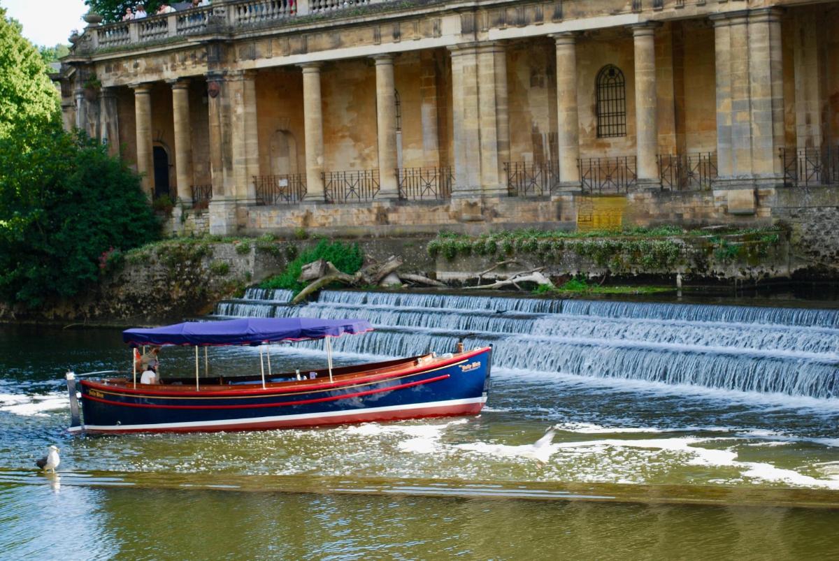 a boat in the water next to a fountain