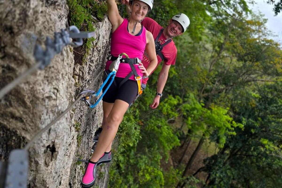 a man and woman climbing on a rock wall