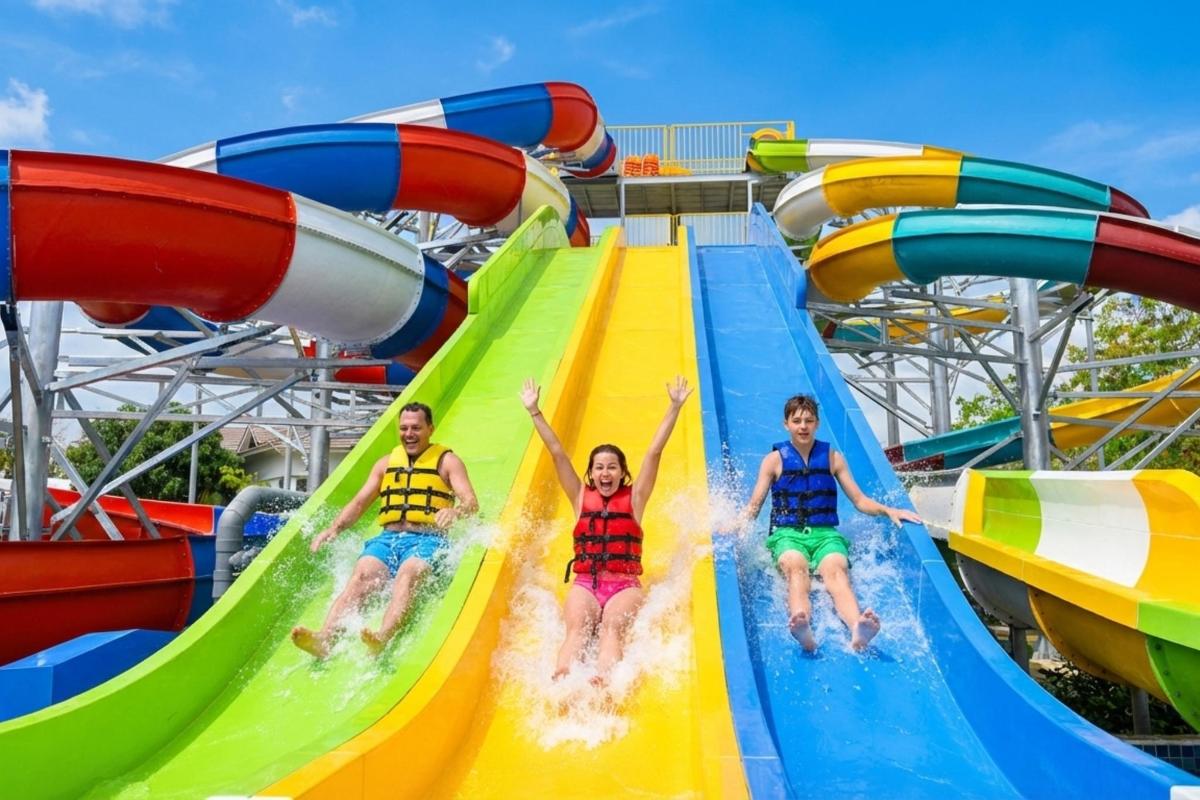 three people riding down a water slide at a water park