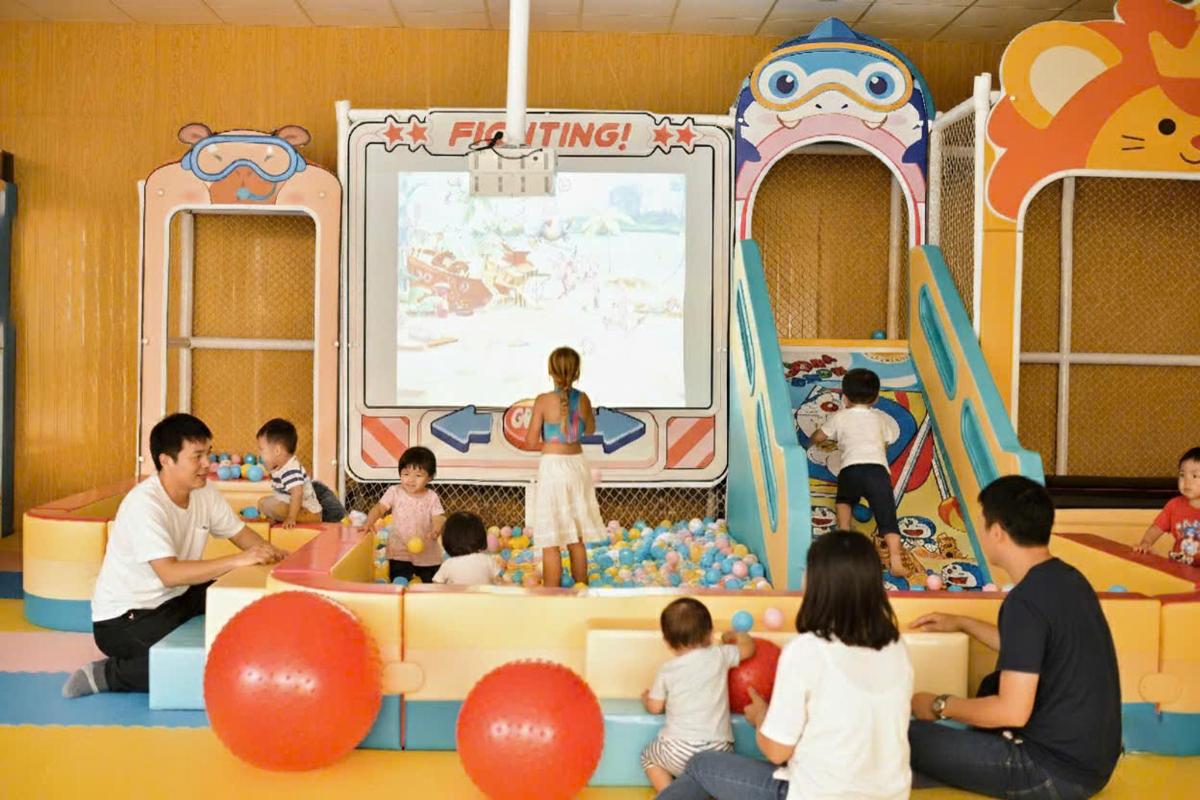 a group of children playing in an indoor playground