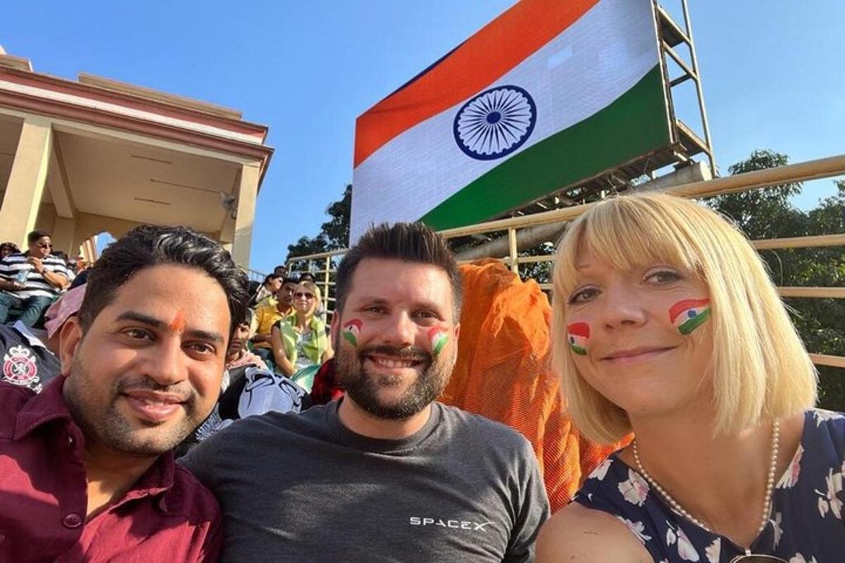 two men and a woman with painted faces in front of a flag