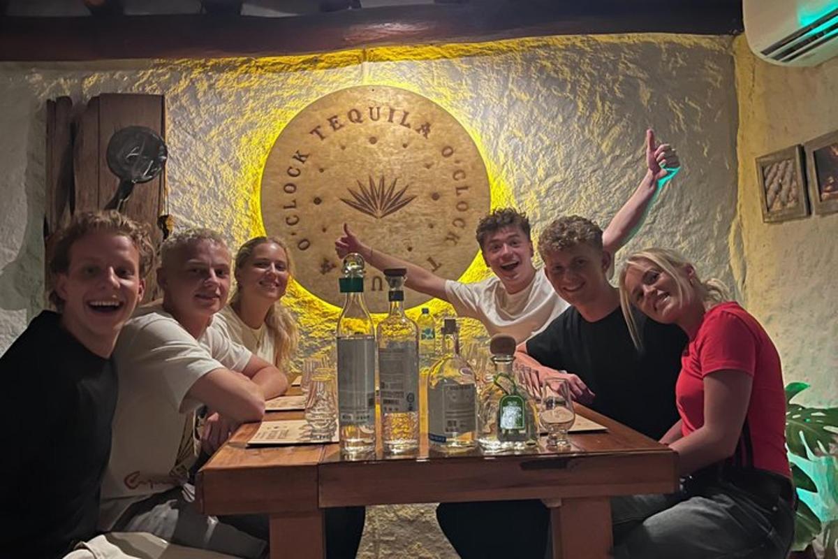 a group of people sitting around a table with wine bottles