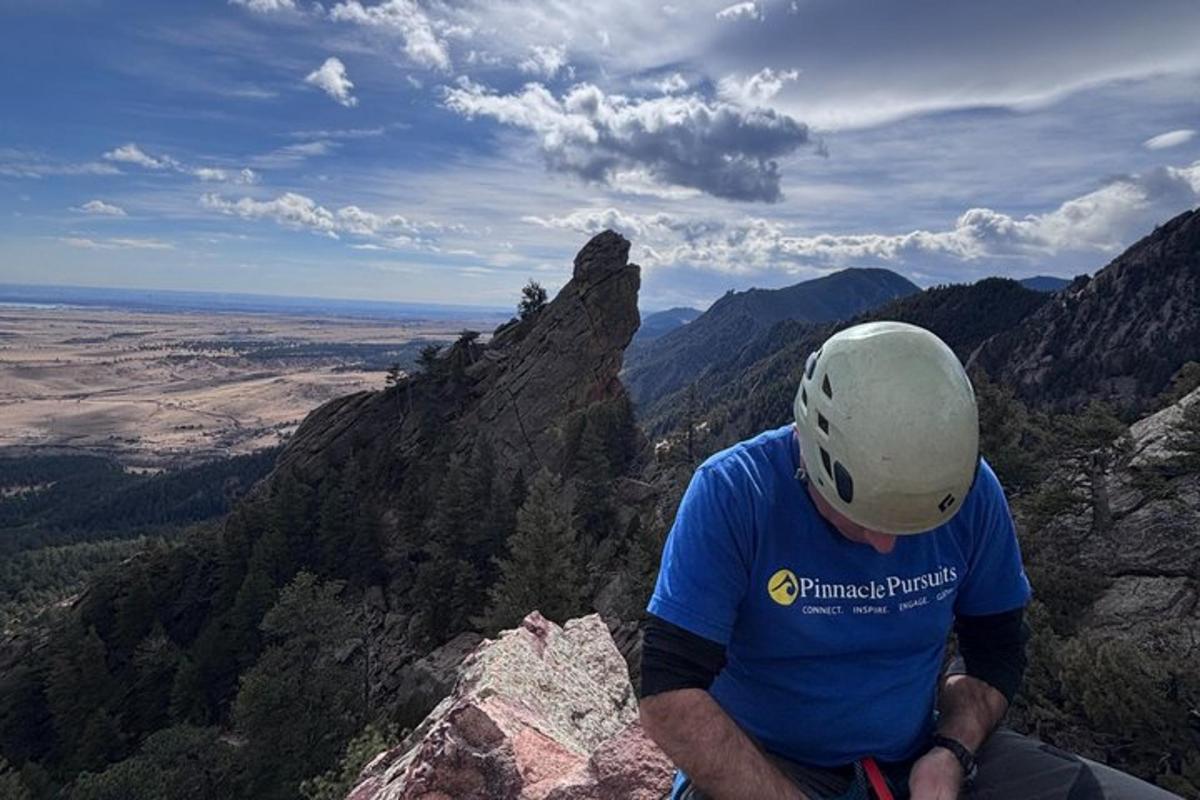 a man sitting on the edge of a mountain