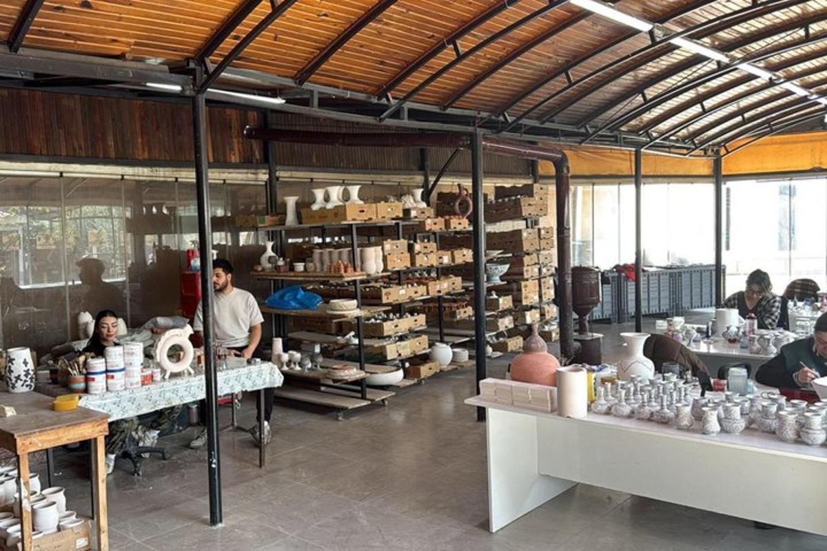 a group of people working in a pottery shop