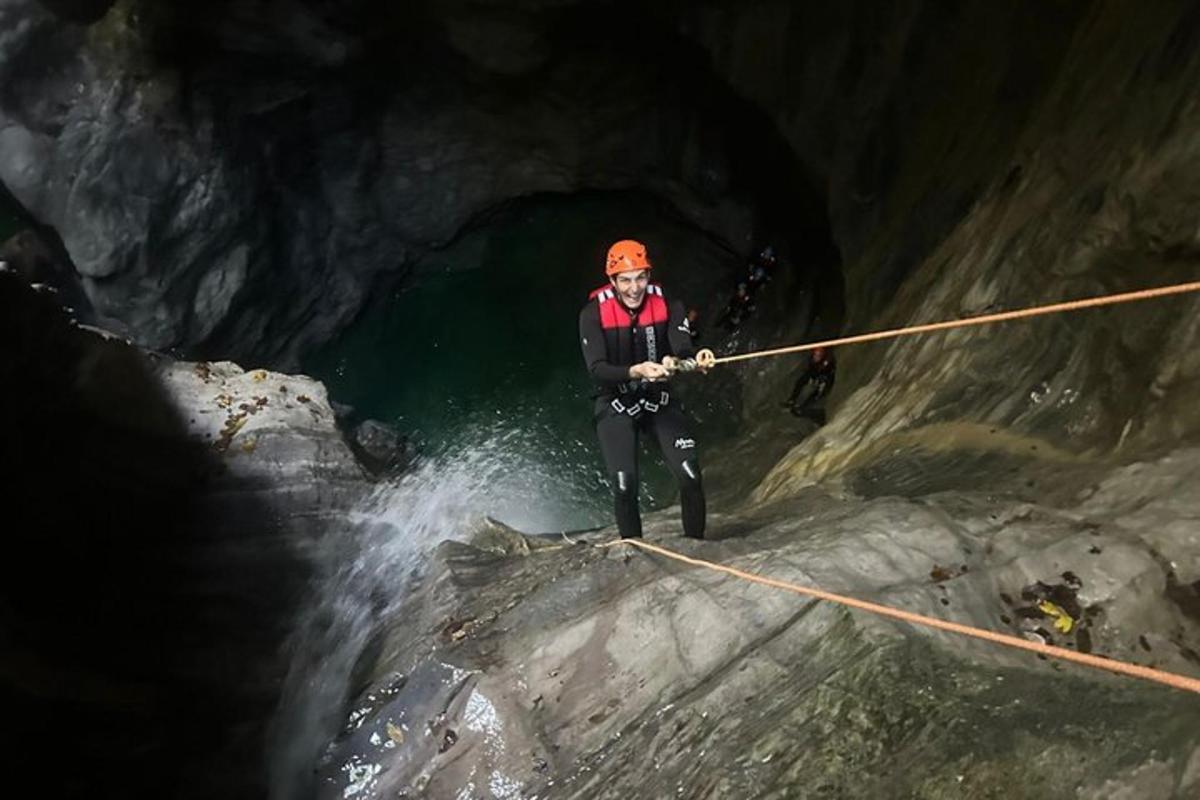 a man is standing on a rope in a cave