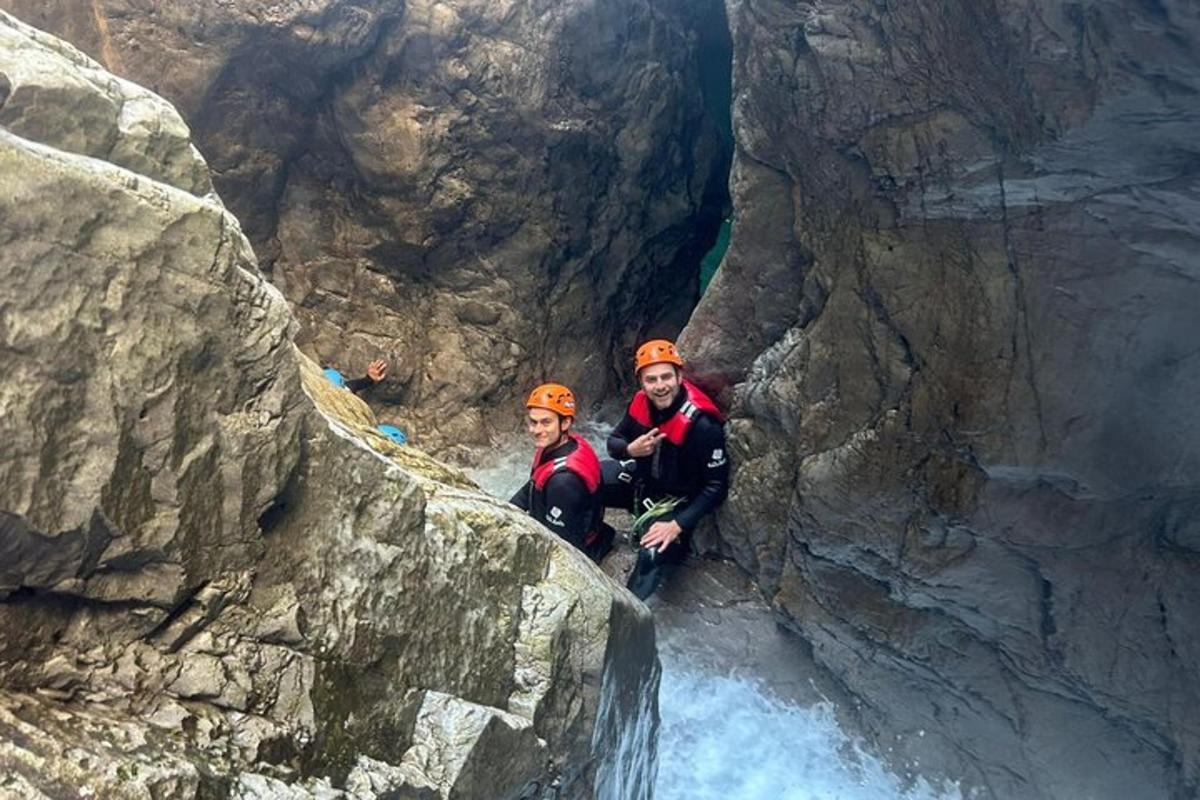 two people are standing in a cave in a mountain