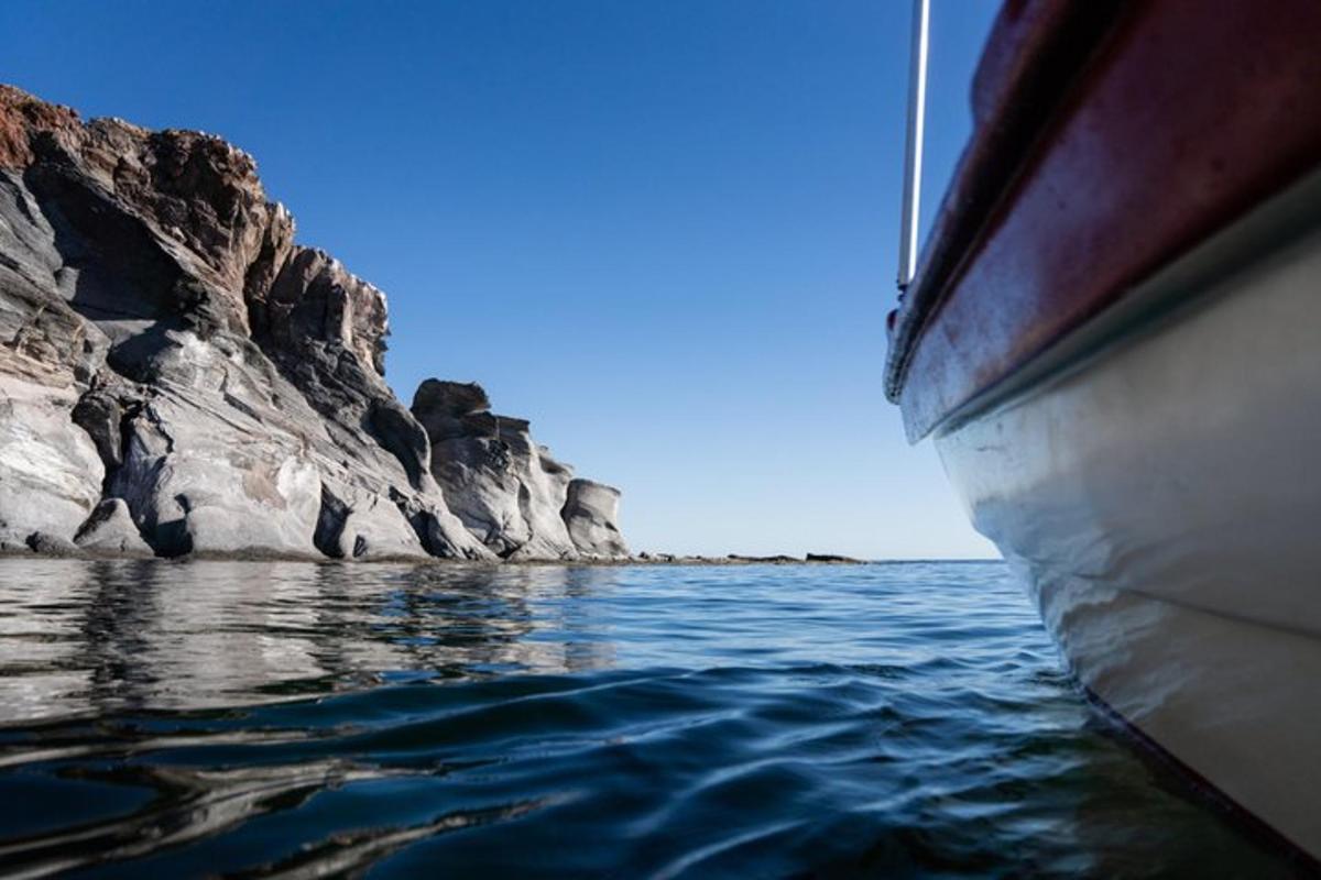 a boat in the water next to some rocks