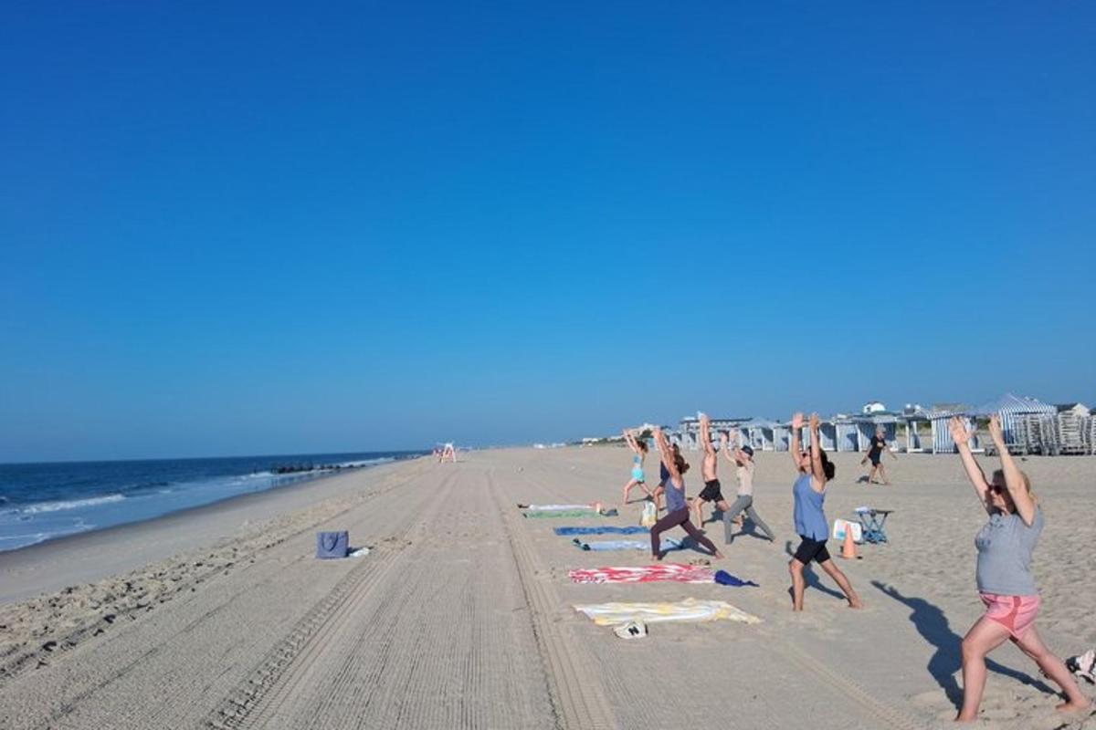a group of people doing yoga on the beach