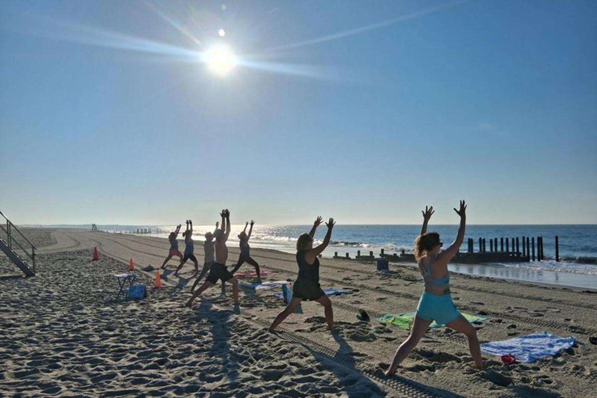 a group of people doing yoga on the beach