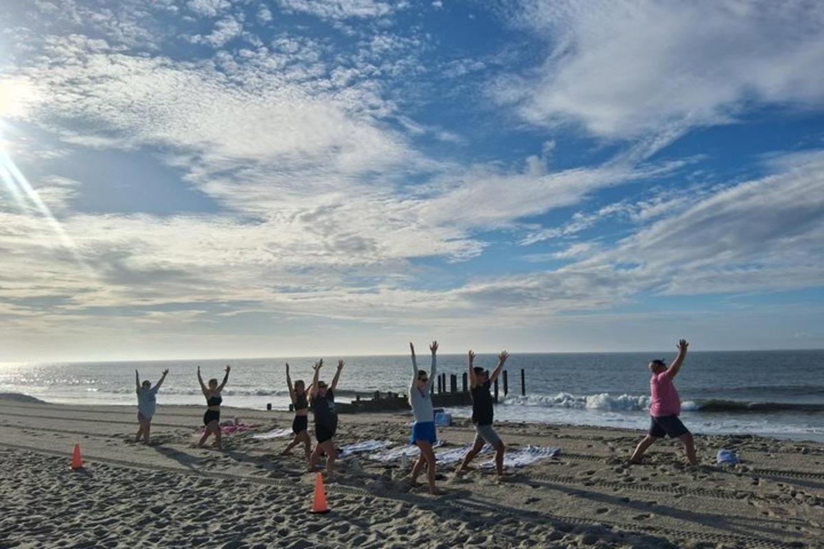 a group of people standing on a beach with their arms up