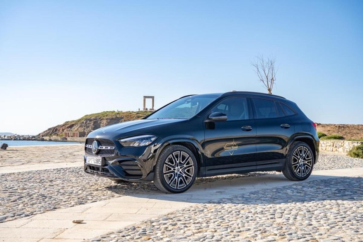a black car parked on a rocky beach