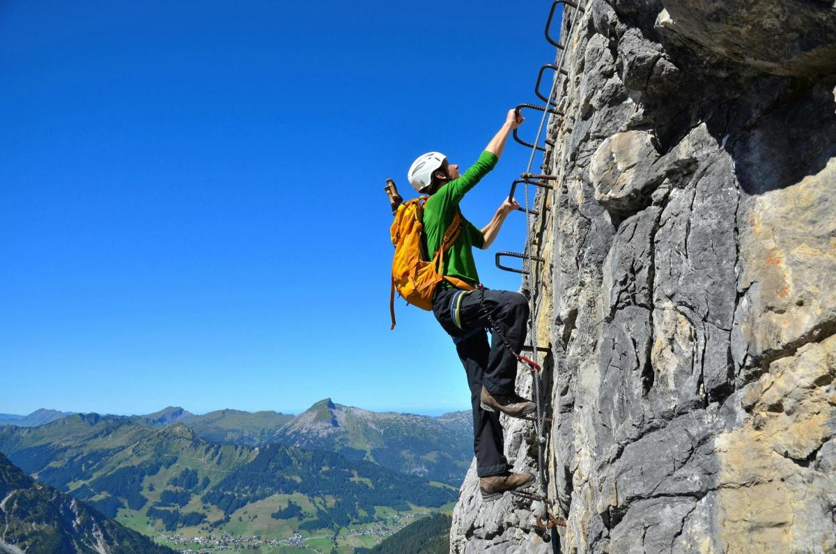a man on a rock climbing on a mountain