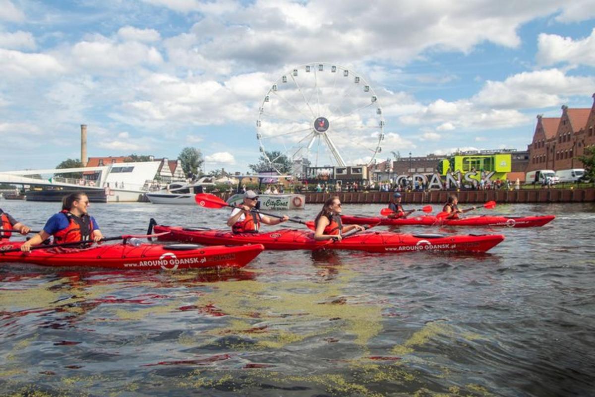 a group of people in red kayaks in the water with a ferris