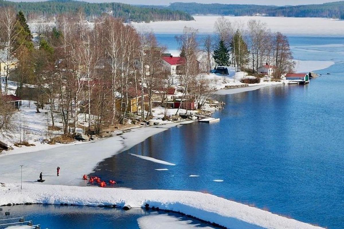 an island in the water with snow on the shore