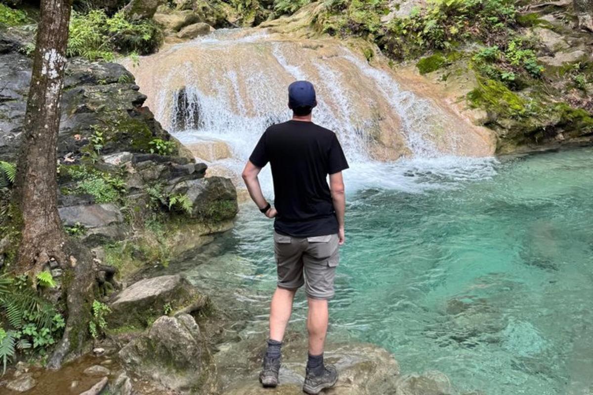 un hombre parado frente a una cascada