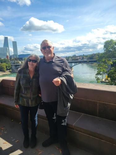 a man and a woman standing next to a river